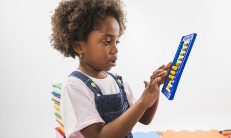 little african girl playing with an abacus game at daycare